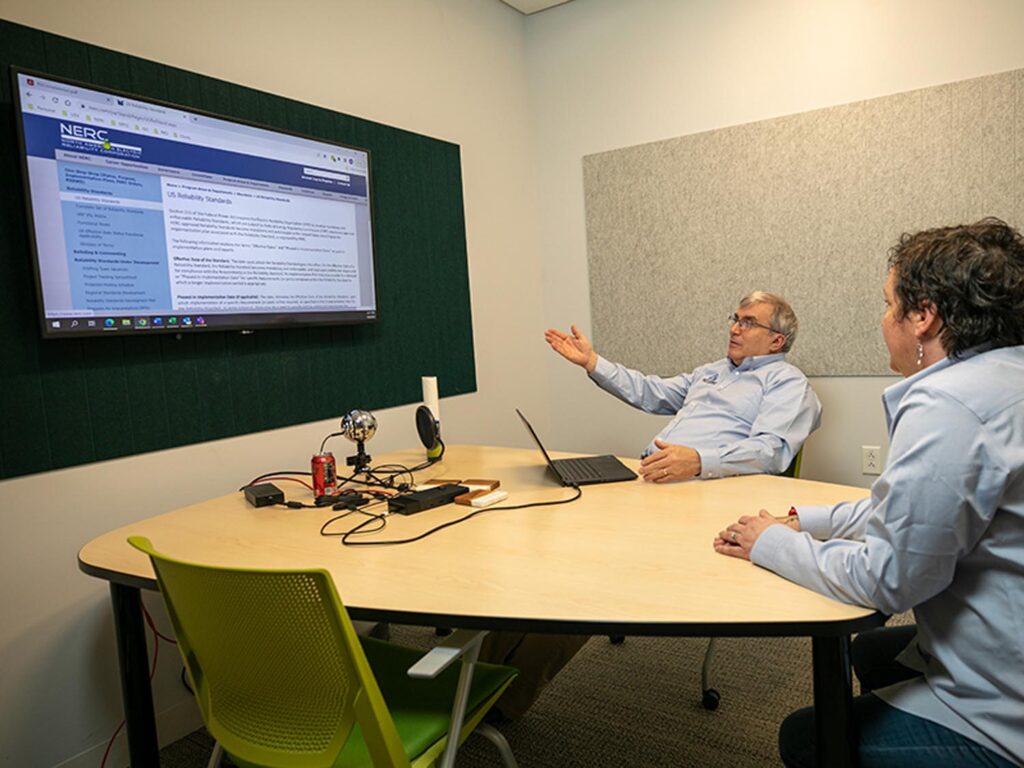 Employees reviewing NERC Alert Notifications